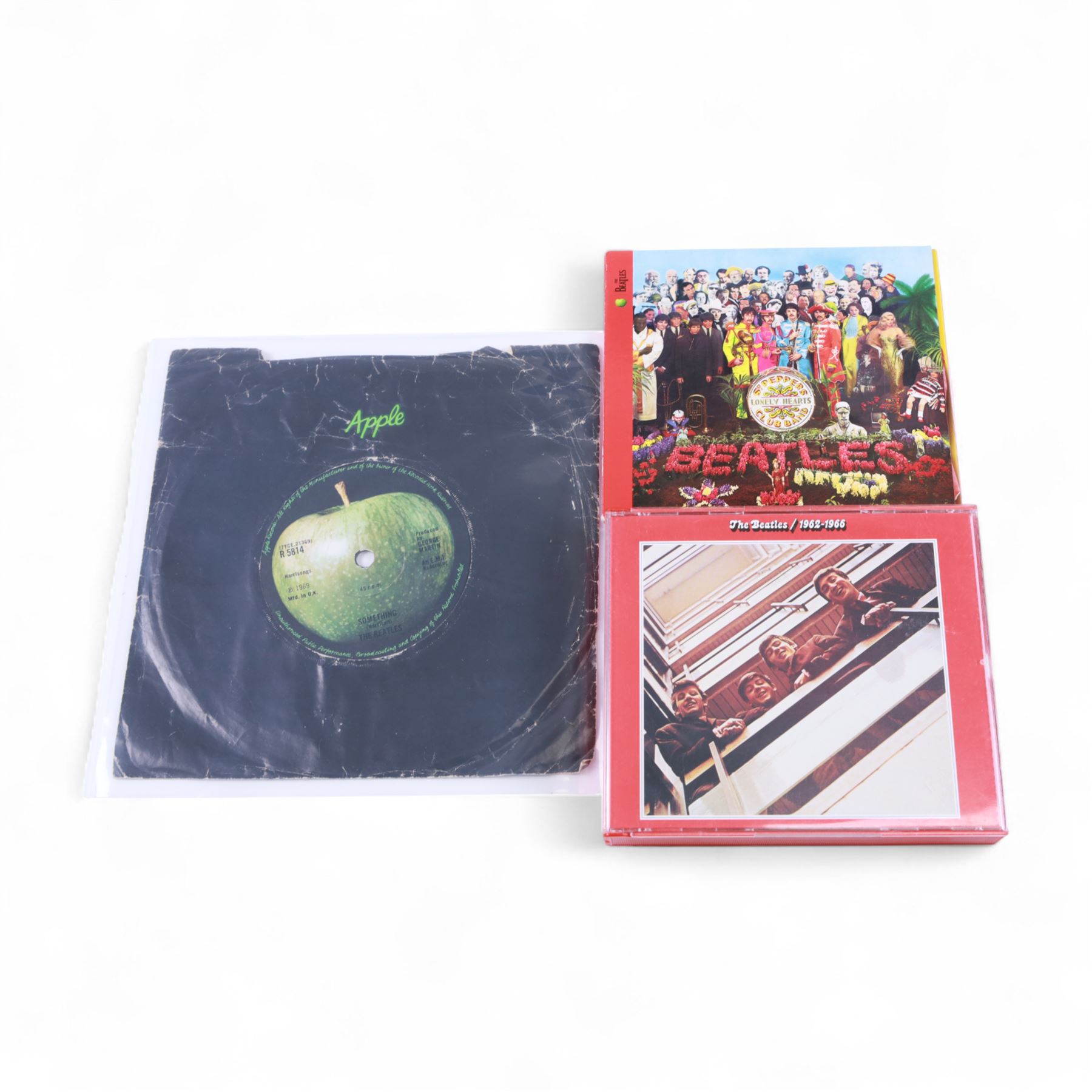 The Beatles memorabilia, including 1964 Fan Club patch, framed with a black and white picture of the band, a further framed black and white picture displayed with Strawberry Fields Forever single, The Beatles Anthology, biographies and other books, two CDs, mug, etc