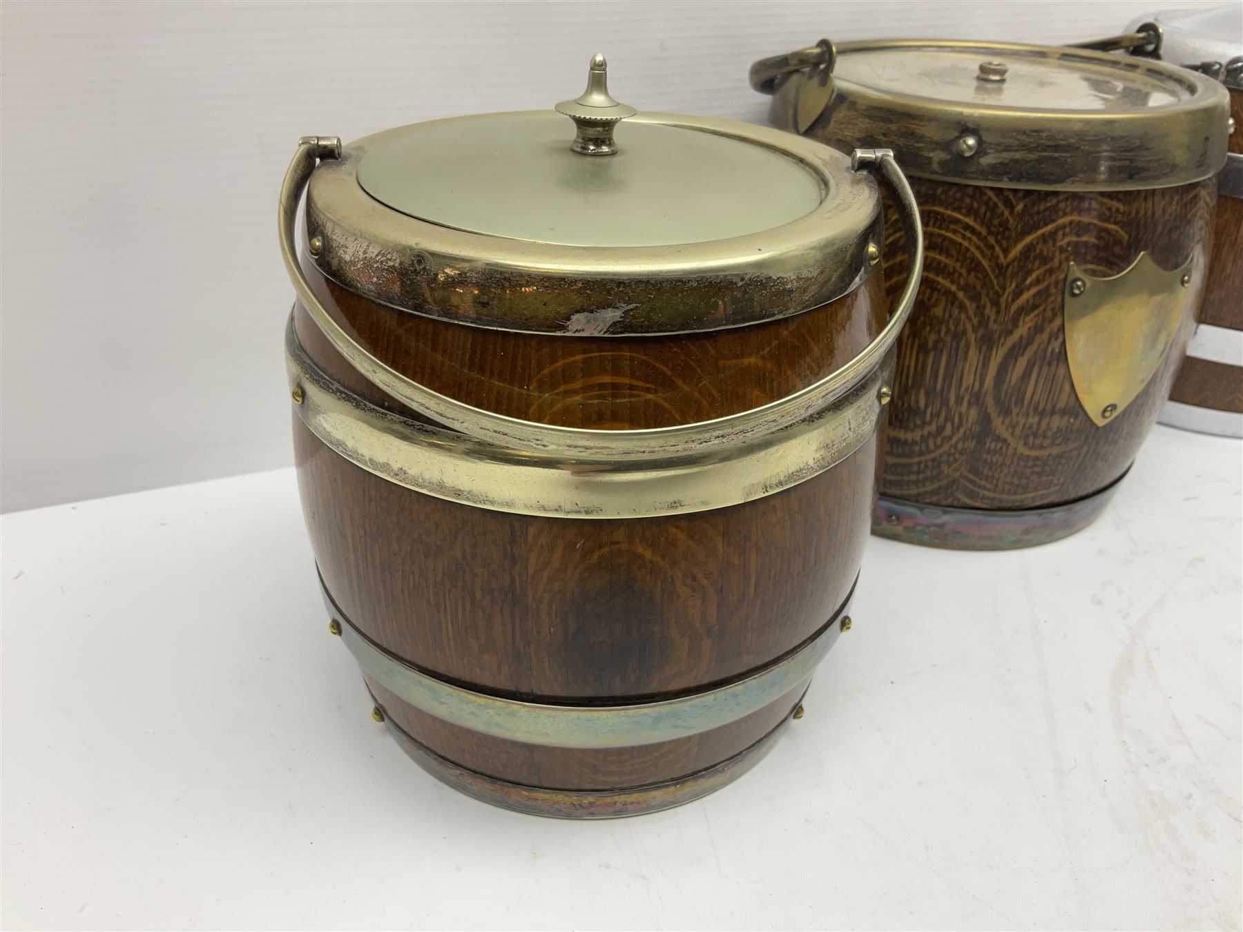 Five early 20th century biscuit barrels with silver-plated mounts