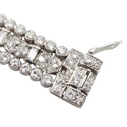 Art Deco platinum diamond and ruby bracelet, circa 1920-1930, the central panel set with a single emerald cut diamond of approx 0.55 carat, flanked by two baguette cut diamonds and old cut diamond surround, the articulated geometric design bracelet with vari-cut rubies, round and baguette cut diamonds, total diamond weight approx 7.00 carat, in Mappin & Webb silk and velvet lined box