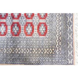 Jaldar Bokhara crimson and pale ground carpet, the field decorated with five rows of Gul motifs, within intricate multi-band border decorated with repeating geometric designs 