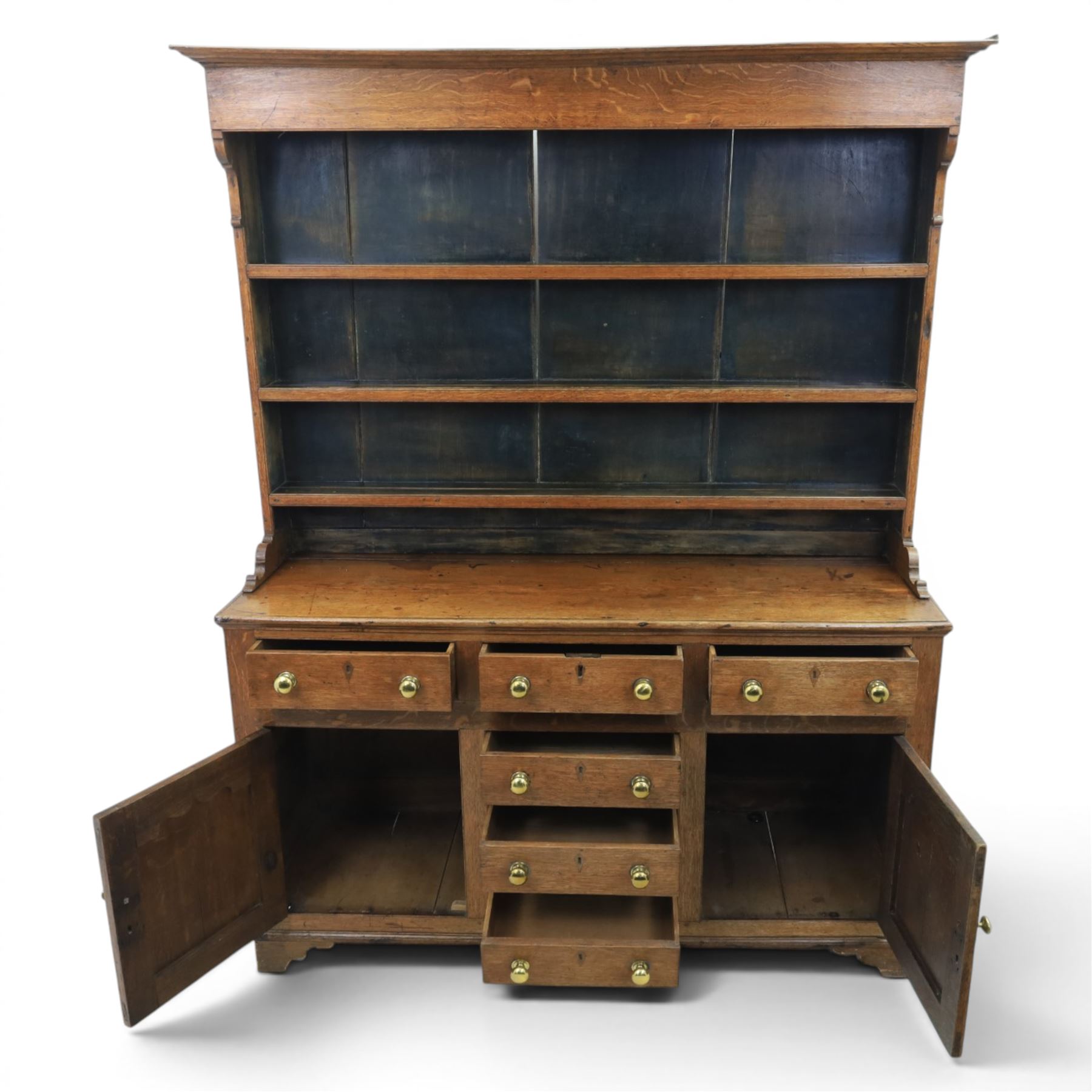 18th century Georgian oak dresser and rack, three back-boarded plate shelves, above six drawers and two cupboards, raised on bracket feet