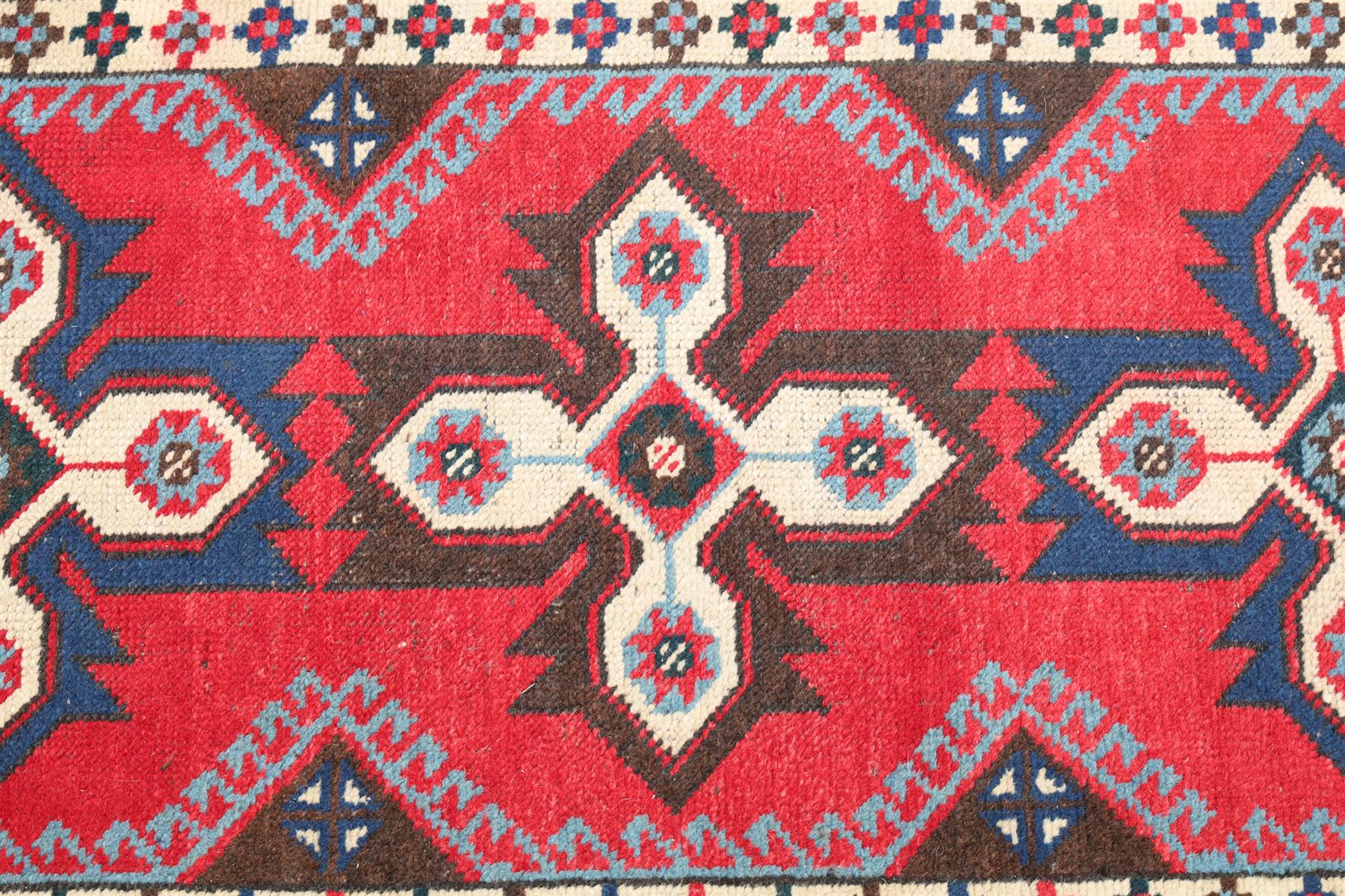 Two Persian rugs, Persian Hamadan hand-knotted rug, ivory ground centred by a terracotta medallion, surrounded by scrolling floral and foliate motifs, dark navy floral border with narrow guard stripes, fringed ends, H 176cm, W 75cm, Persian tribal hand-knotted rug, madder red ground decorated with three large geometric medallions, surrounded by angular motifs, enclosed by multiple geometric borders in dark navy, ivory and red, fringed ends, H 150cm, W 91cm