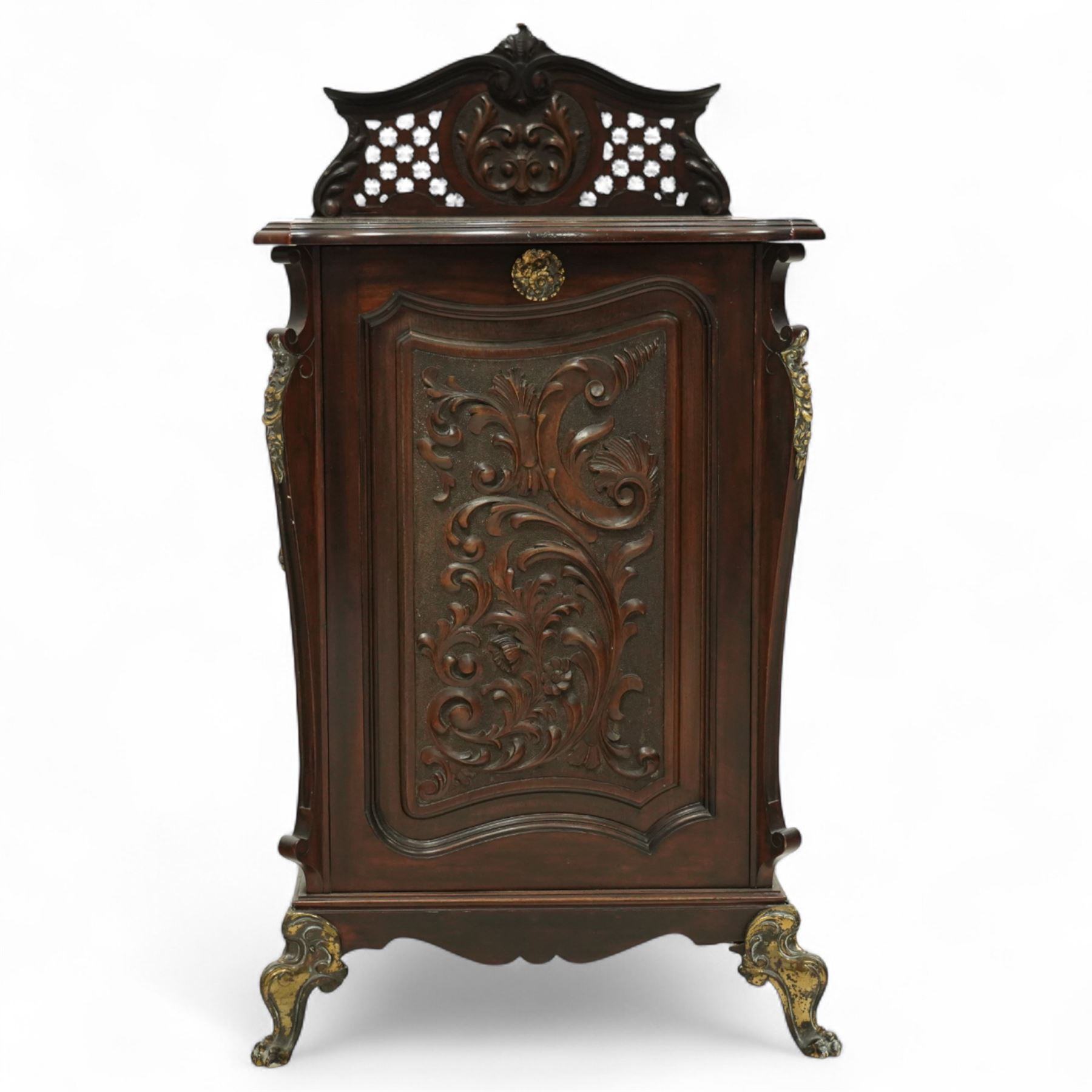 Late Victorian mahogany coal purdonium, the serpentine front door carved with scrolling foliage, surmounted by a pierced and foliate crest, brass carrying handles to sides, gilt metal mounts and cabriole legs