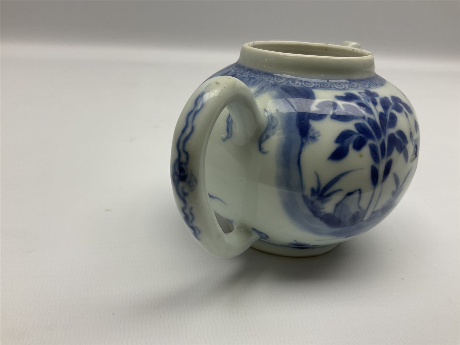 Two late 18th/early 19th century Chinese export teapots, the largest example of globular form with curved handle and straight spout, decorated in the Mandarin style with figural scenes surrounded by red scale reserves, H13.5cm, the second smaller example decorated in underglaze blue with two musicians in a landscape set with willow tree and fence, H10.5cm

