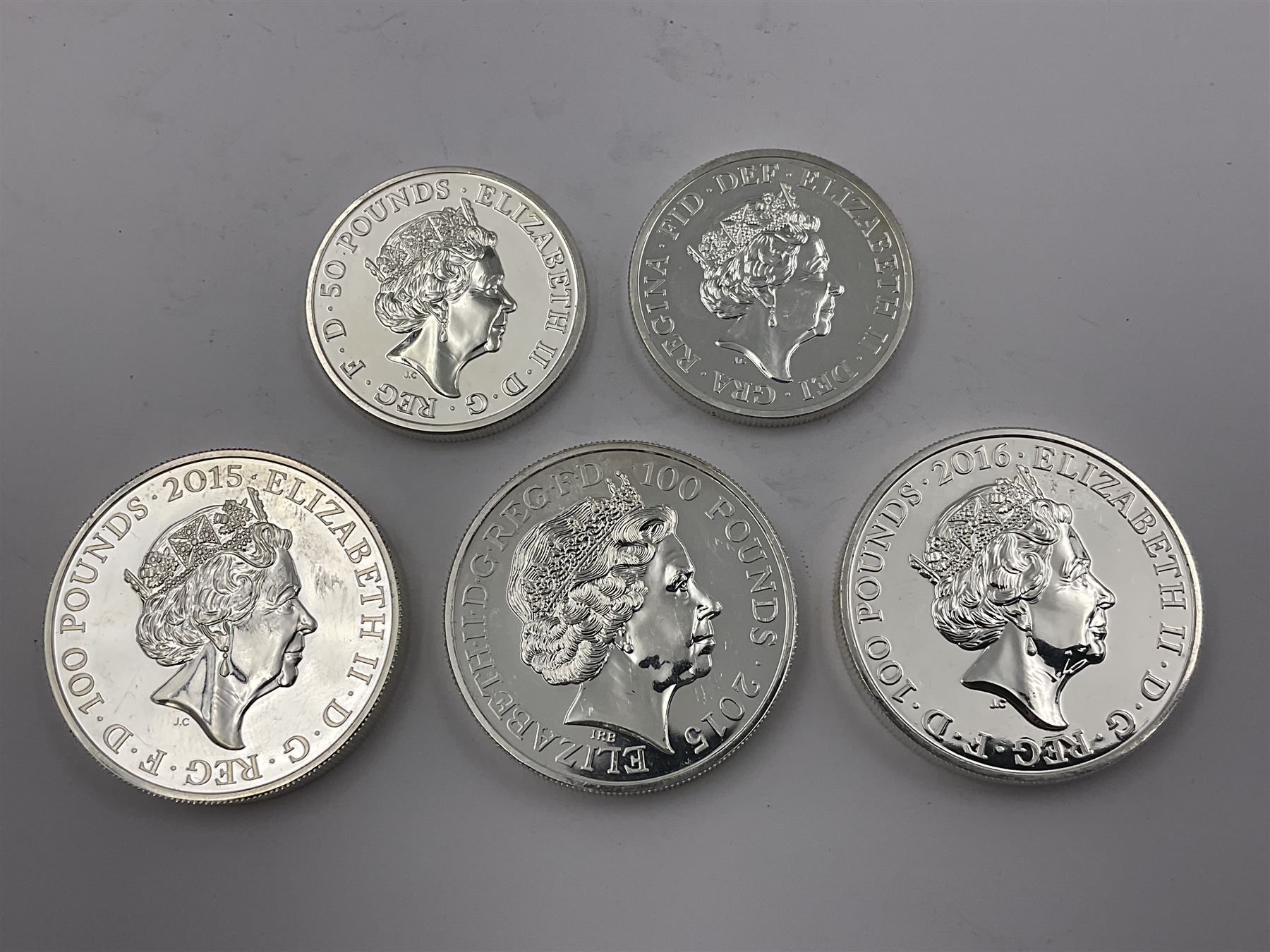 Five The Royal Mint United Kingdom fine silver coins comprising 2015 ‘Buckingham Palace’, 2016 ‘Big Ben’ and 2016 ‘Trafalgar Square’ one hundred pound coins, with 2015 ‘Britannia’ and 2016 ‘The Shakespeare Histories’ fifty pound coins