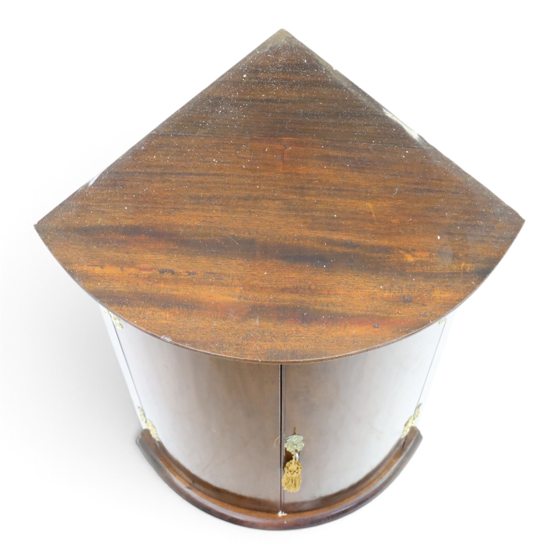 Small Georgian mahogany cylindrical hanging corner cabinet, projecting cornice with dentil carving, brass H hinges and escutcheons