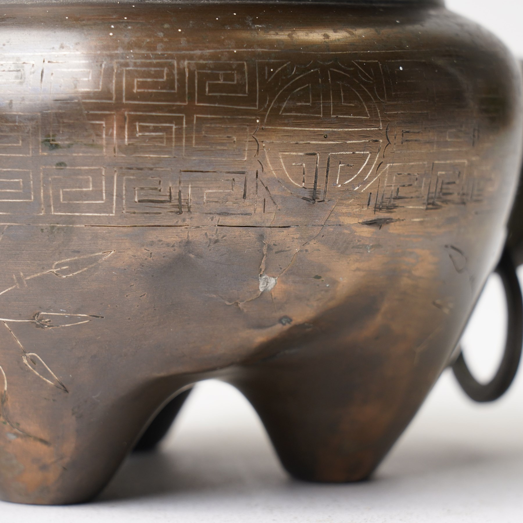 Chinese bronze tripod censer, of squat globular form, the body decorated with a band of Greek key motifs, the twin handles formed as two elephants heads, with incised shi shou two-character mark to base, H10cm
