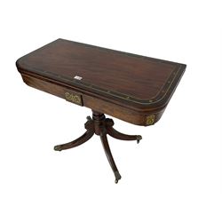 Regency mahogany tea table, rectangular fold-over top with rosewood banding and brass inlays, turned pedestal with four splayed supports carved with acanthus leaves, brass hairy paw cups and castors