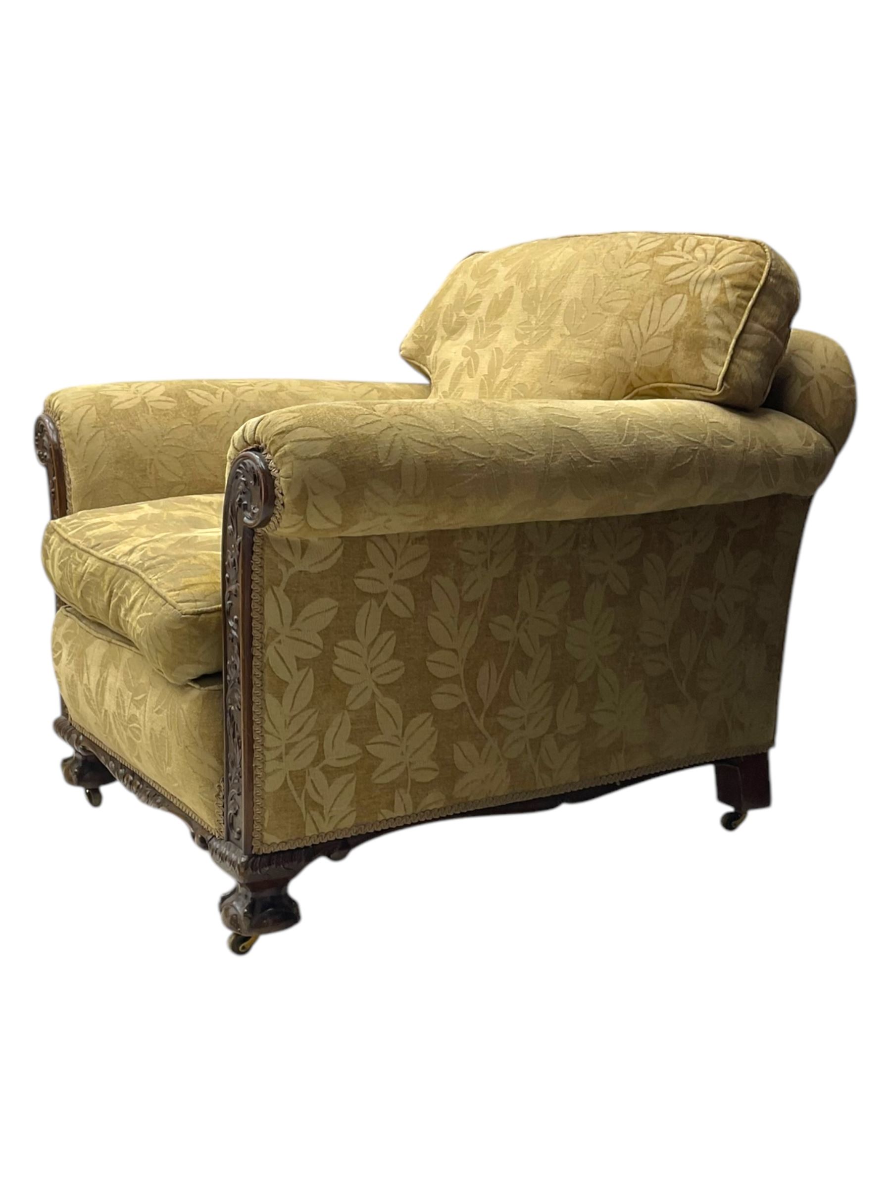 Early 20th century mahogany framed three-piece lounge suite - three-seat camelback sofa (W203cm, D105cm); pair of matching armchairs (W95cm, D96cm); upholstered in neutral foliate pattern fabric, carved with trailing leafy branches, ball and claw carved feet with brass castors 