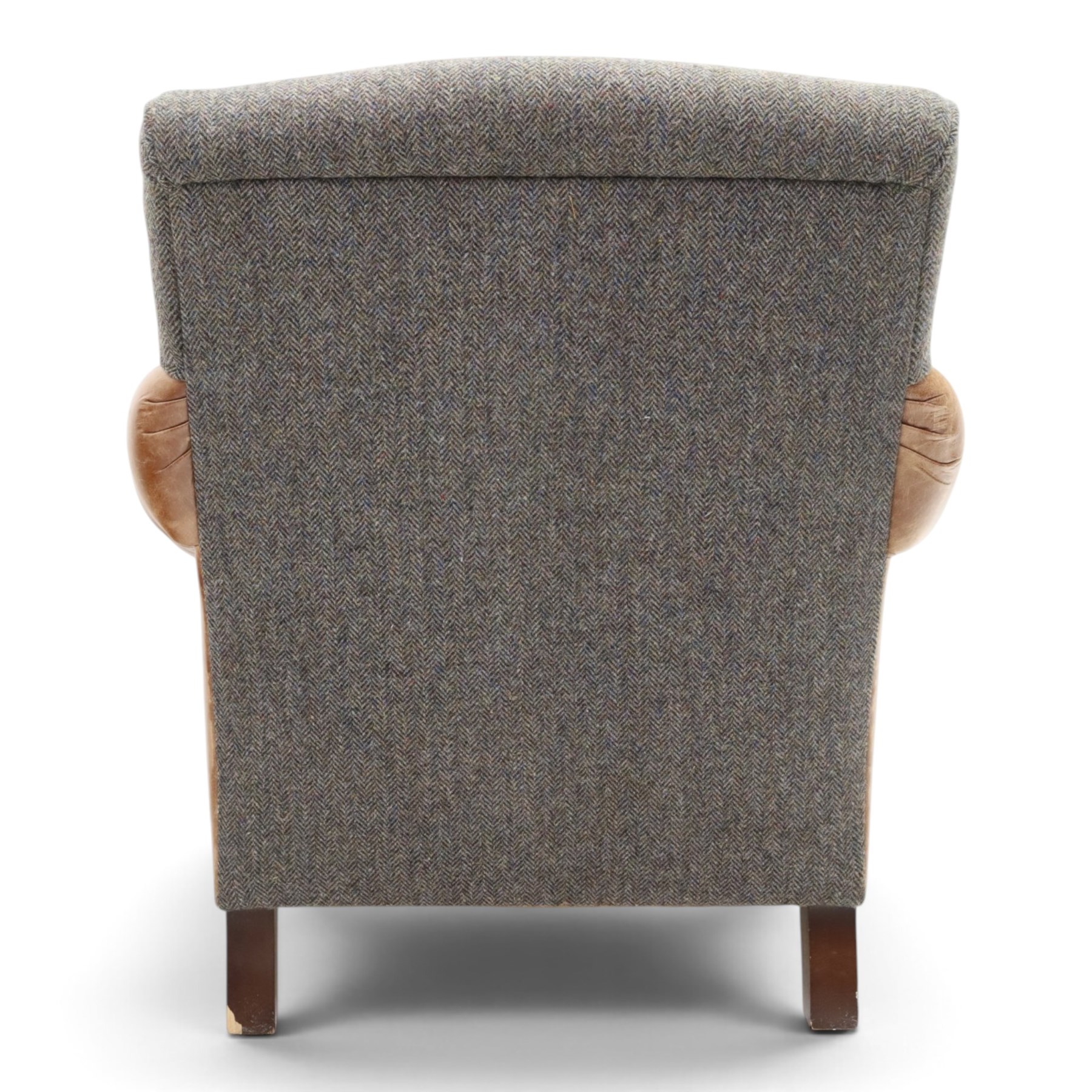 Tetrad - 'Taransay' Harris Tweed and tan leather club armchair, Howard shape with reclined back over deep seat and rolled arms with studwork, raised on turned front supports with castors, the sides and arms upholstered in tan leather with seat and back in herringbone-stitched Harris Tweed