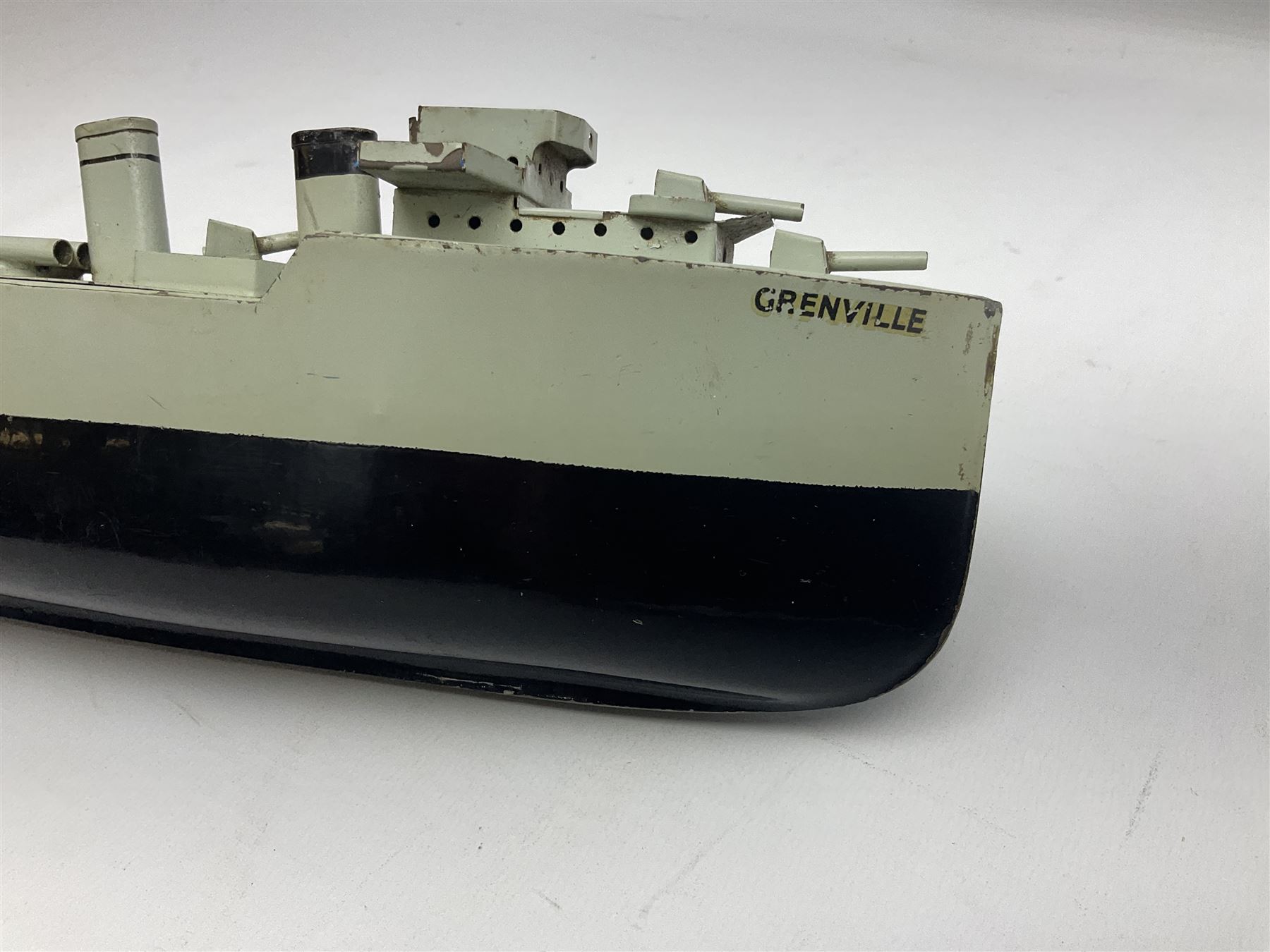 Pre-war Sutcliffe Grenville tinplate clockwork Battleship, with black and grey hull, grey deck and upper decks, propeller and rudder, length 32cm; with manuscript biographical details and two keys, unboxed