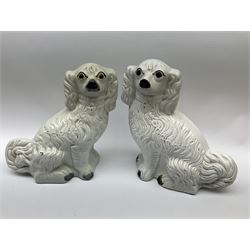 A pair of Victorian Staffordshire white glazed spaniels, together with two Victorian Staffordshire models of greyhounds, the largest modelled with hare in mouth, largest greyhound H27cm. 