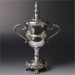 Mid 20th century silver twin handled trophy cup and cover, the bowl with central mask mounted girdle upon a knopped stem and spreading circular foot with flower head mounted paw feet, the tapering stepped cover with leaf moulded knop finial, hallmarked Vaughton & Sons, Birmingham 1938