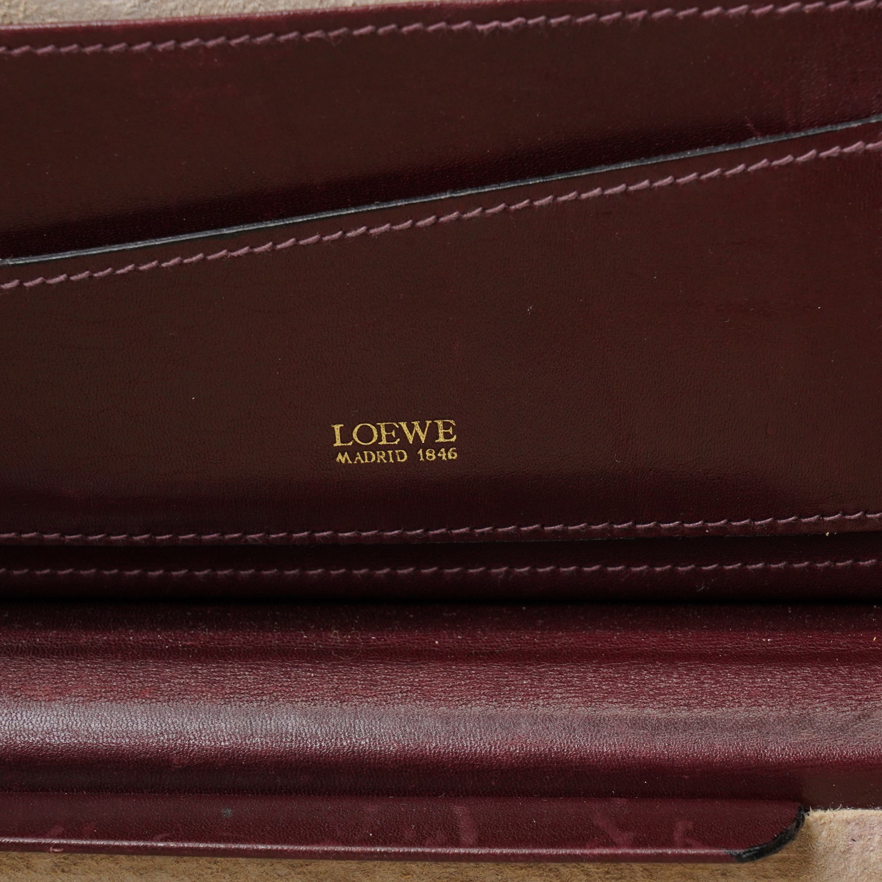 Loewe - vintage burgundy leather attaché case, the exterior embossed with Loewe Anagram, with gilt-tone hardware, twin combination locks and leather handle, opening to a suede-lined fitted interior with document compartments, pen loops and pockets, stamped LOEWE Madrid 1846