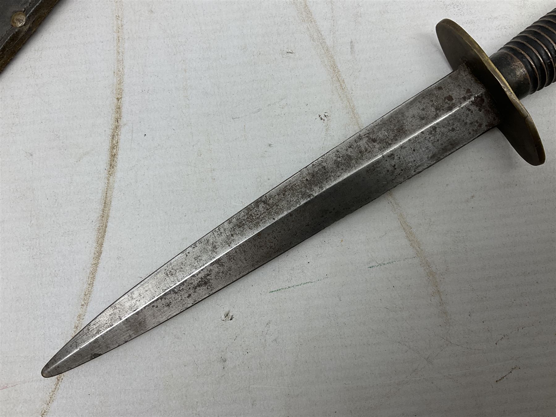 Fairburn and Sykes Commando fighting knife, 3rd pattern with 17cm double edged blade and copperised grip; no markings; in cut-down plain leather sheath L31.5cm