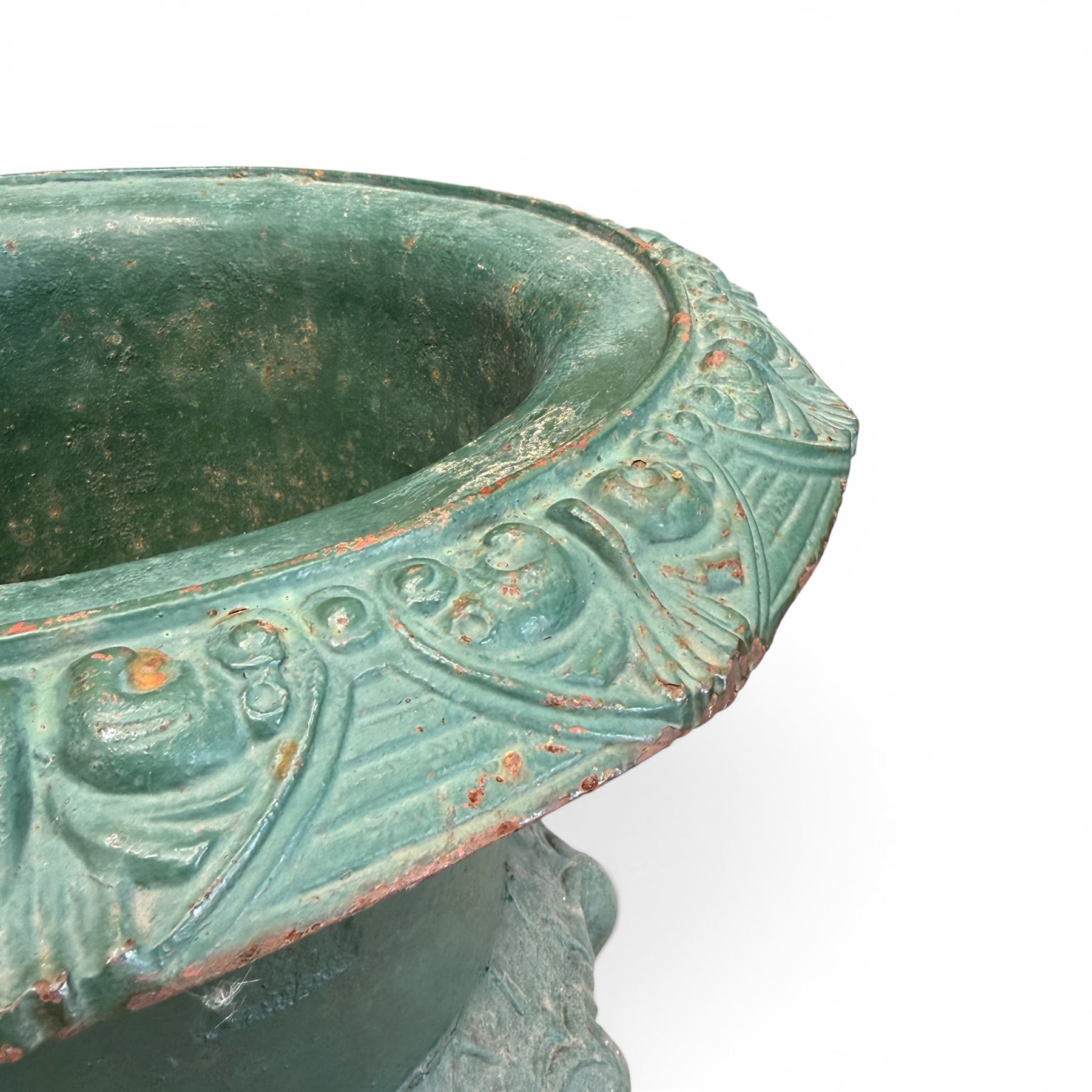 Pair of Victorian cast iron campana garden urns, the flared rim with repeating stylised anthemion motifs with scrollwork, over a deep gadrooned and Aesthetic moulded underbelly, fluted and foliate lower bowls on square pedestal bases, in antique green-painted finish