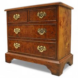 Late 20th century figured walnut miniature chest, the rectangular top with feather banded border over two short and two long drawers, fitted with brass batwing handles, upon moulded plinth base and four bracket feet, H60cm, w67cm, D36cm