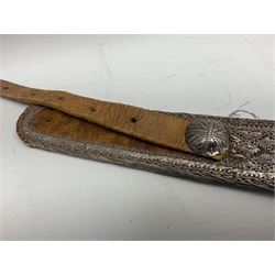 Omani Khanjar dagger, the 19cm curved blade with pronounced medial rib to either side, waisted hilt with dome shaped pommel and silver covered horn grip decorated with filigree bands, floral motifs and beadwork; in an intricately filigree decorated silver and leather scabbard with silver rings woven into the belt mount and fitted with original silver thread-work belt L34cm overall belt length 94cm