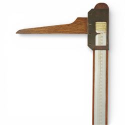 Early 20th century French oak height and balance scales, with graduated vertical rule, adjustable counterweight mechanism with brass and steel fittings, raised on a stepped rectangular oak base, bearing brass maker’s plaque, signed Kuhn & Fleichel, Jarville