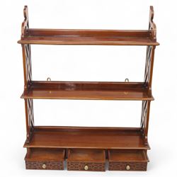 Two mahogany wall hanging items, comprising a French mahogany overmantel mirror with reeded uprights and moulded cornice (H 68cm, W 97cm, D 10cm), together with a mahogany wall shelf unit with three tiers and fretwork sides, the lower section fitted with three small drawers (H 95cm, W 63cm, D 18cm) (2)