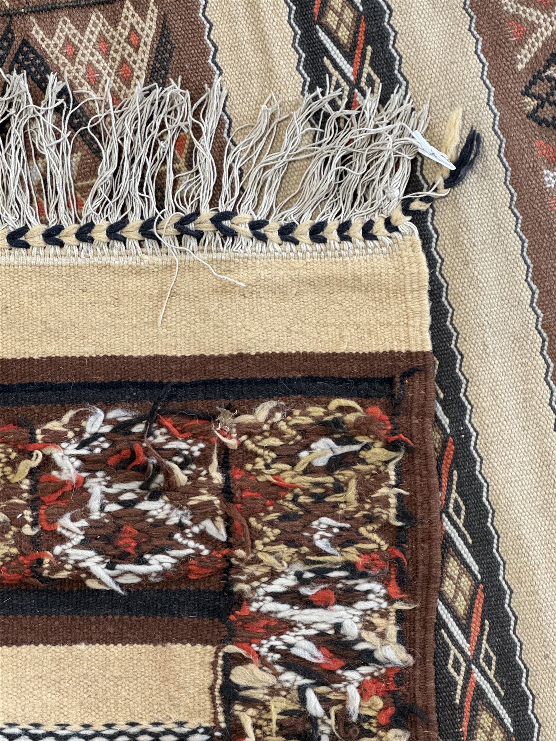 Turkish Kilim ground rug, the field with alternating horizontal bands of geometric patterns, bordered by repeating diamond motifs (145cm x 242cm); Turkish red ground rug, the field with three octagonal medallions (113cm x 172cm) (2)