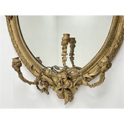 Victorian giltwood and gesso oval girandole mirror, floral cartouche pediment with scrolled leafage, egg and dart decorated frame and slip, decorative rose and berry mounts, with three candle sconces