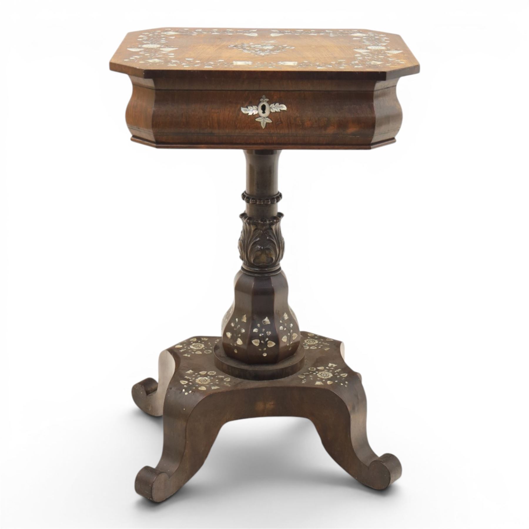 Victorian mahogany and mother-of-pearl inlaid work table, the octagonal hinged top enclosing a mirror and fitted compartmented interior, raised on a carved pedestal and quatriform platform base with scrolled feet