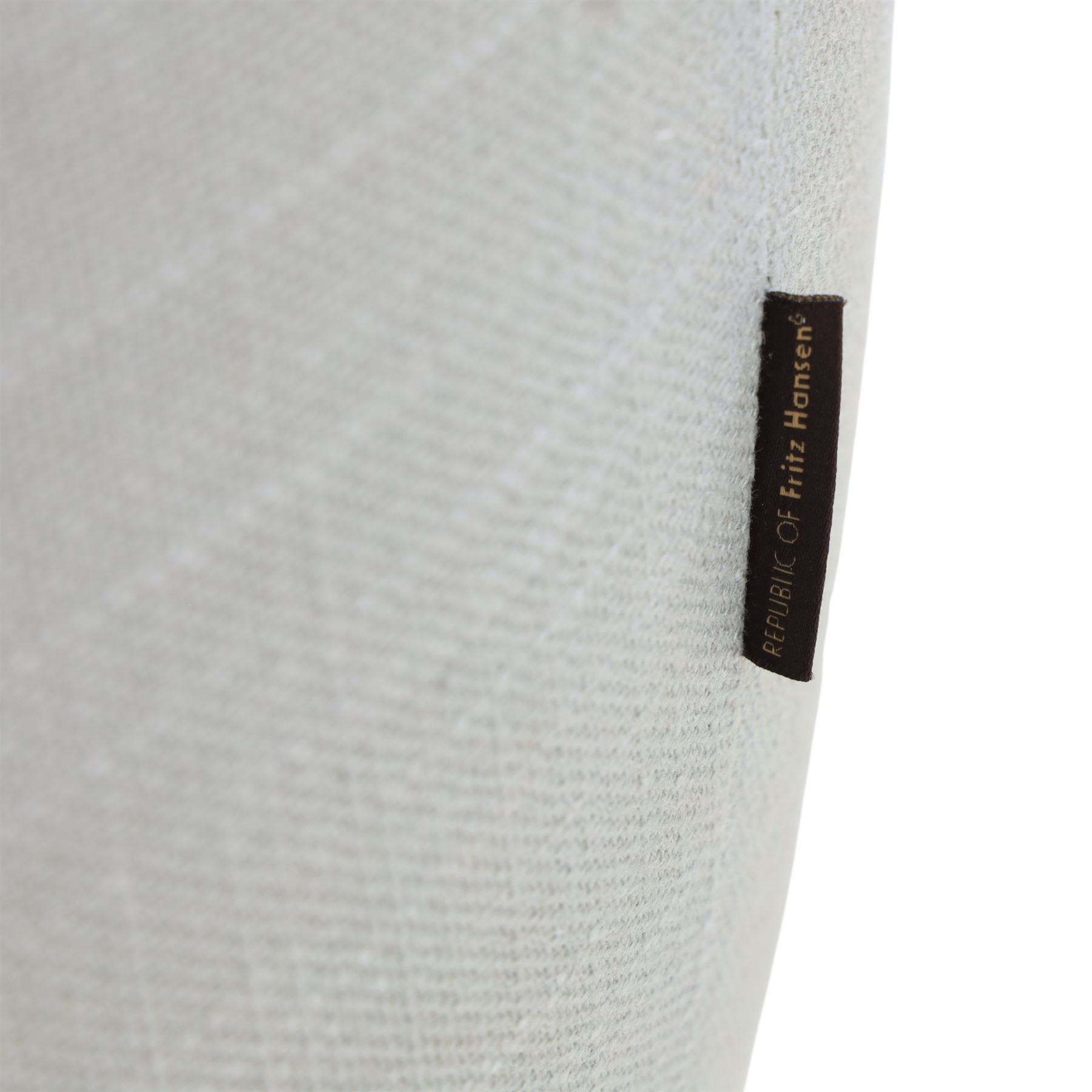 Fritz Hansen - 'Favn' sofa, designed by Jaime Hayon (1974-), upholstered in light grey fabric, the organic curved back and integrated arms enclosing loose seat and back cushions, raised on slender cylindrical metal supports