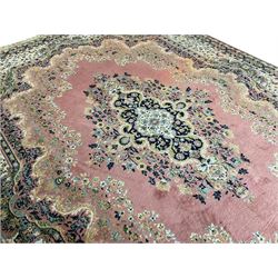 Large Persian design peach ground carpet, the field decorated with floral medallion, multi-band border decorated with repeating flower head pattern