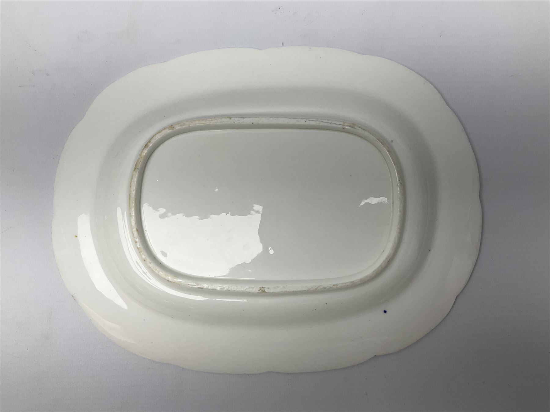 Three 19th century plates, comprising two circular examples and one oblong, each with osier moulded sides, the centres decorated in underglaze blue with Gillyflower type pattern, circular examples D25cm oblong example W27cm