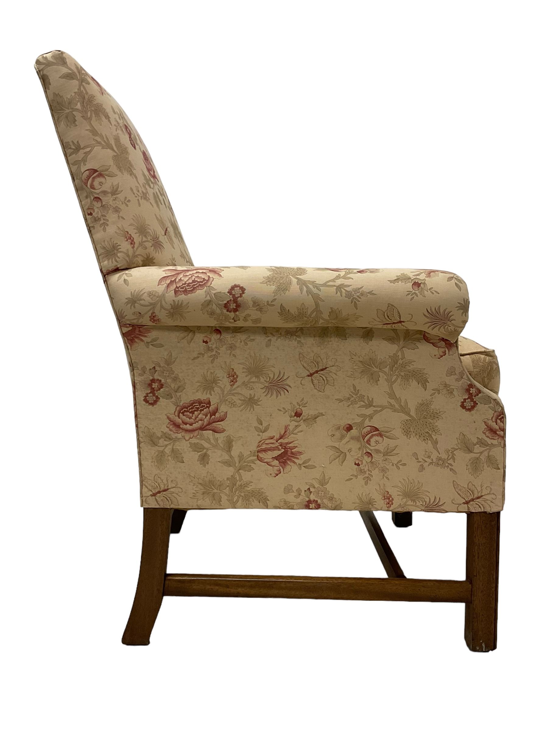 Peter Dudgeon - Georgian design mahogany framed armchair, shaped cresting rail over sprung back and seat flanked by rolled arms, upholstered in floral patterned fabric with matching seat cushion, on square supports joined by stretchers
Provenance: From the Estate of the late Dowager Lady St Oswald