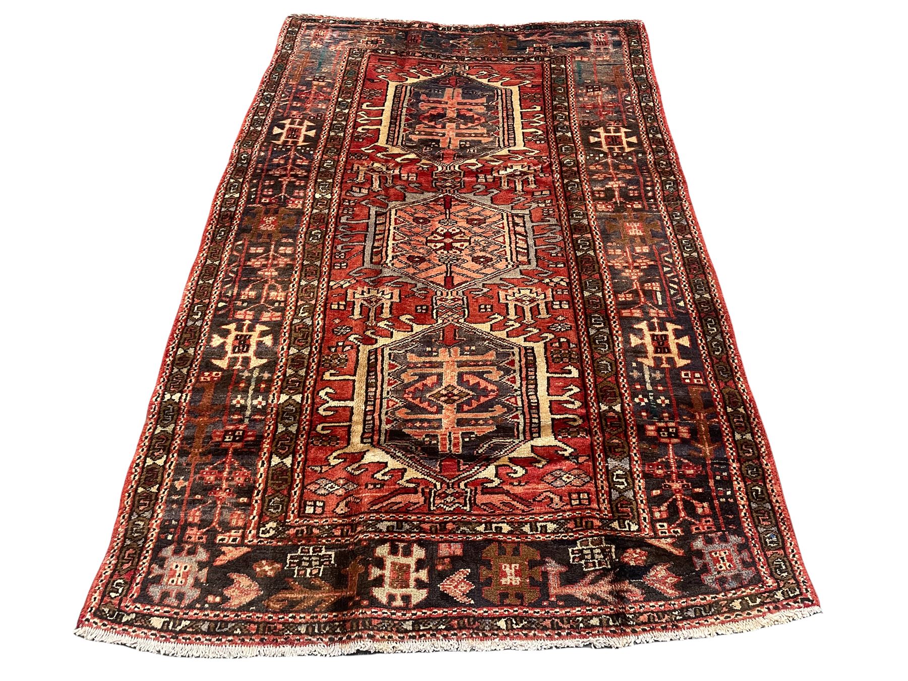 Persian Heriz red ground rug, the field decorated with three medallions