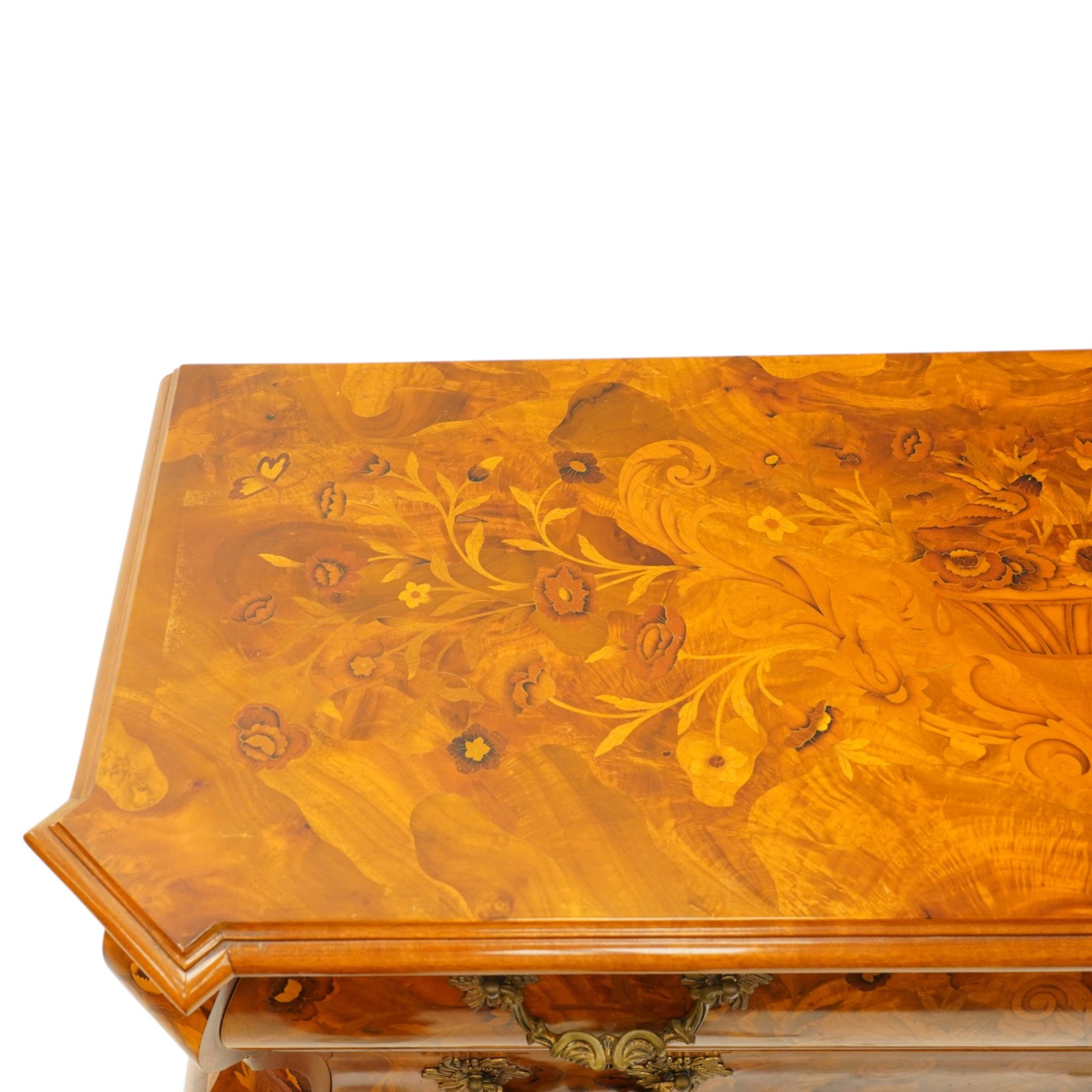 Colombo Mobili - Italian walnut and floral marquetry bombé commode chest, rectangular top with canted eared corners inlaid with urn motif and trailing scrolling foliage, fitted with three long graduating drawers with gilt metal handles, profusely inlaid with scrolling acanthus leaves interspersed with urns and cartouches, on large carved ball-and-claw feet
