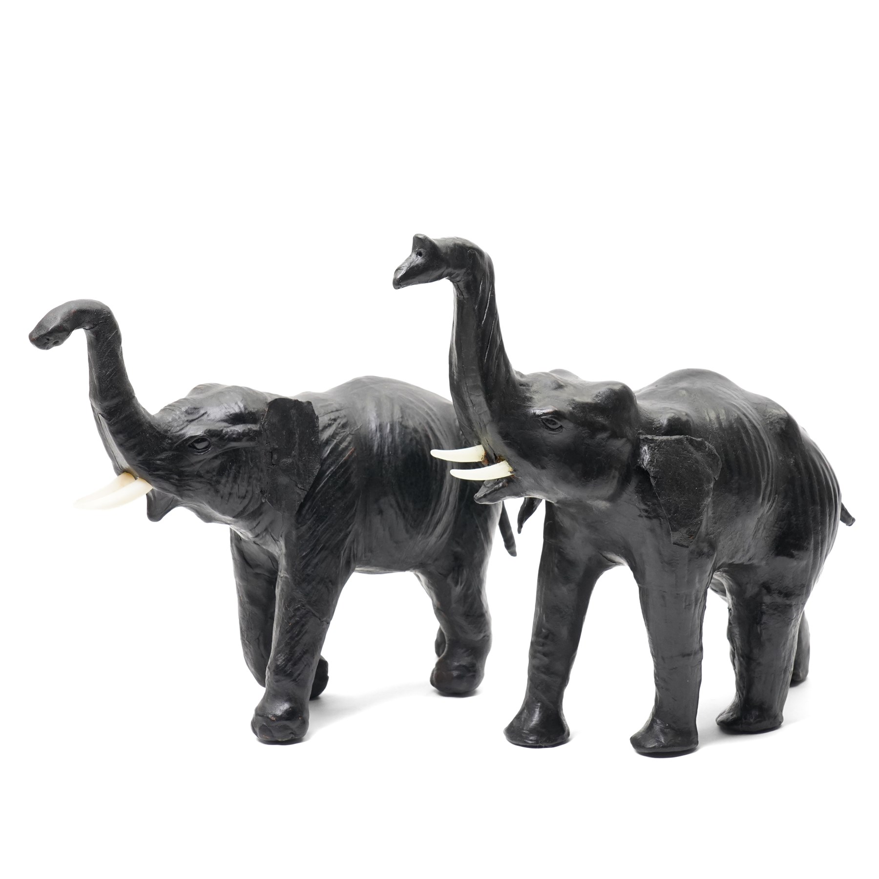 In the style of Liberty & Co - pair of 20th century ebonised papier mache elephants 