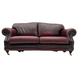 Thomas Lloyd - three seat sofa upholstered in red leather, turned front feet with brass castors