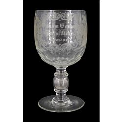Early 19th century oversized glass goblet, the bowl engraved with dedication 'William Carlson Horn of Plenty London', surrounded by roses, thistles, and shamrocks, emblematic of the Union, above a faceted base, and upon a hollow knopped stem containing a silver George IV sixpence and circular foot, H24.5cm