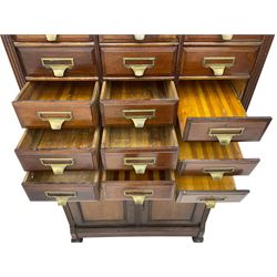 The Shannon Limited - late Victorian walnut filing cabinet, fitted with twenty-four small filing drawers, each with brass handle with label holder, fluted uprights, double cupboard below enclosed by two panelled doors, on turned feet, with brass plaque inscribed 'The Shannon, Limited, Ropemaker St. London, E.C.'