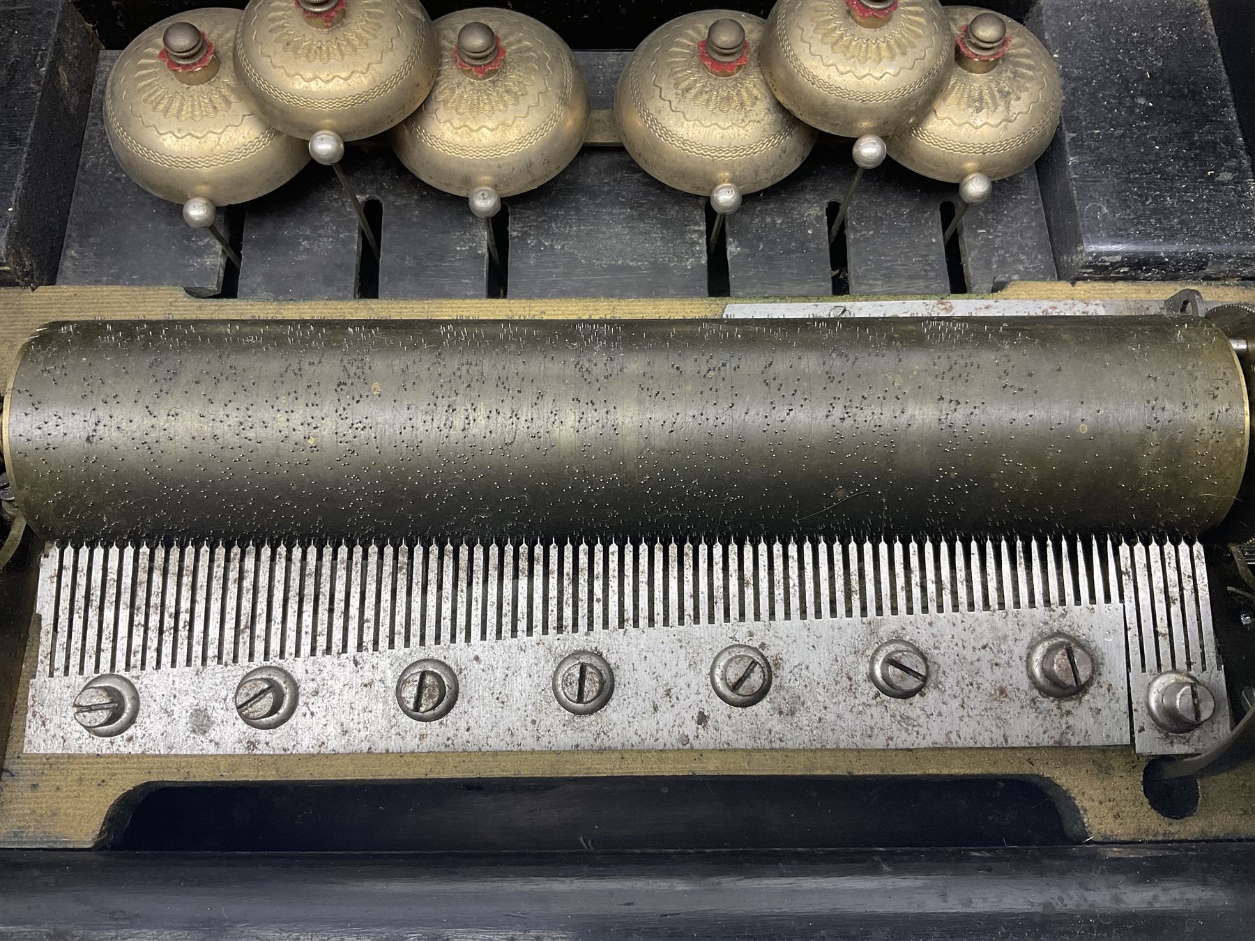 Large late 19th century Swiss bells-in-sight musical box with 27.5cm cylinder playing eight airs on a 27cm two-piece comb with seventy-seven teeth and six graduated engraved saucer bells with strike/silent facility; in crossbanded rosewood and ebonised case, the front and hinged lid inlaid with musical trophies, opening to reveal a song card under the lid and hinged glazed cover to the movement; serial no.7539 L53cm