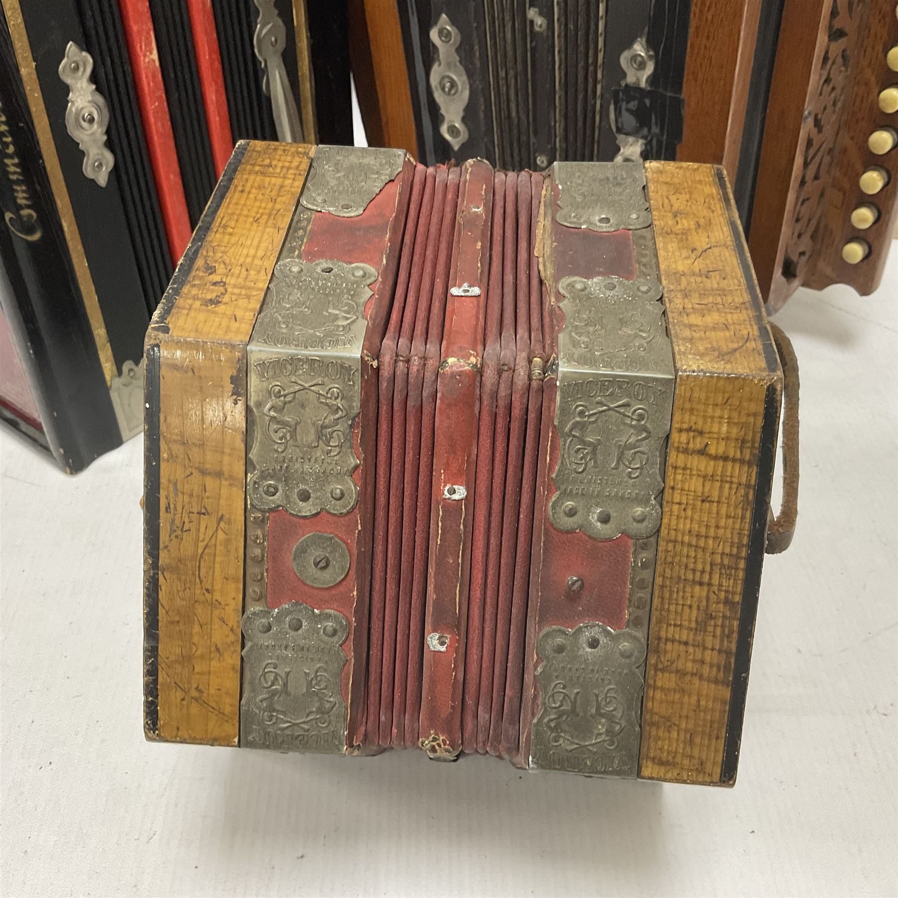 Three European concertinas, comprising Viceroy German concertina with 21 keys, hexagon wooden frame and 8 fold bellows
Oak framed concertina with 12 keys and 8 fold bellows
Commander concertina with 12 keys and 12 fold bellows
With tutor