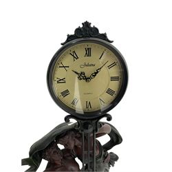 Decorative contemporary “Mystery Clock” with battery operated quartz movement, movement supported by two figures in a classical pose on a circular base, dial inscribed “Juliana”.
