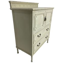 Early to mid-20th century painted tall boy, the raised back decorated with vertical reeded and oval bead motifs, foliate moulded rectangular top over double cupboard and two drawers, decorated with geometric mouldings and flower heads, on turned and reeded feet, in distressed cream paint and waxed finish  