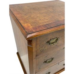 Small Georgian style figured walnut chest, rectangular moulded and crossbanded top over three drawers, the figured drawer fronts with crossband, shaped and engraved brass handle plates, canted uprights, on bracket feet