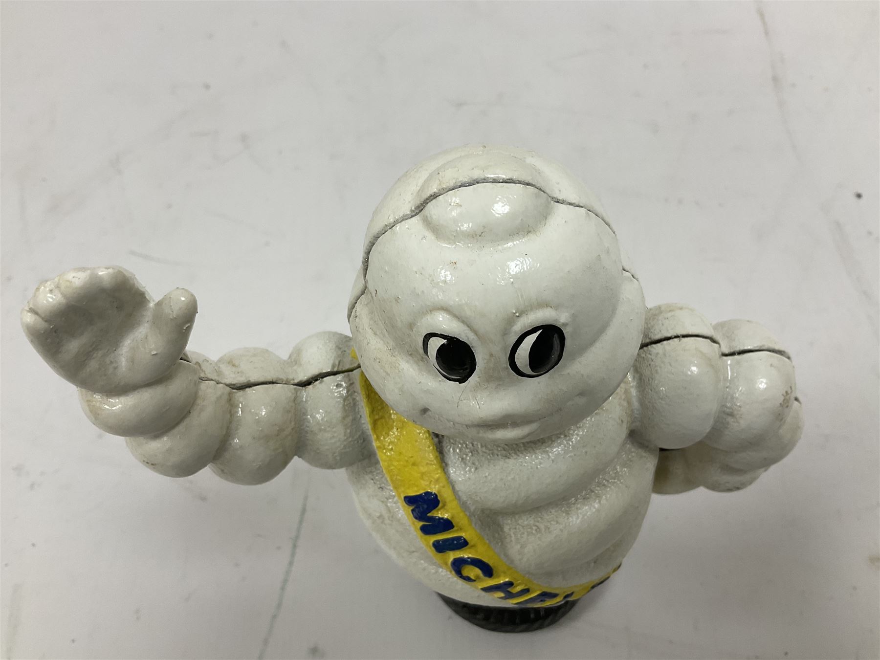Cast iron money bank of a waving Michelin man stood on a tyre, H23cm