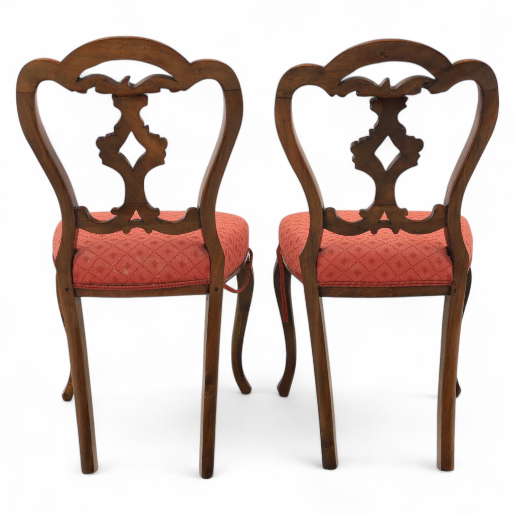 Set of four Victorian walnut balloon back chairs, with a carved and pierced back splat with foliate scrolls, serpentine seat upholstered in a diamond pattern fabric, raised on cabriole legs 