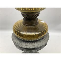 Victorian cast spelter oil lamp, decorated with cherubs and foliate scrolls, supporting a glass reservoir, burner and clear glass chimney, H62cm