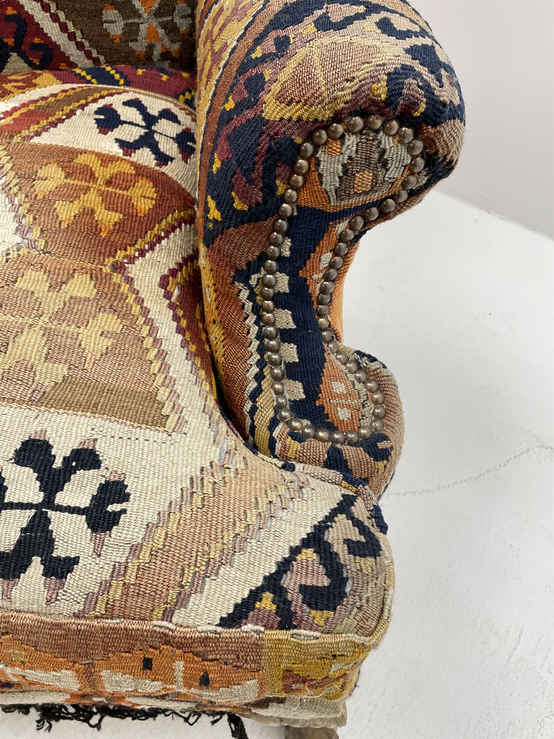 Late 20th century beech framed wingback armchair, sprung seat and back upholstered in kilim cover, acanthus carved cabriole supports with ball and claw feet