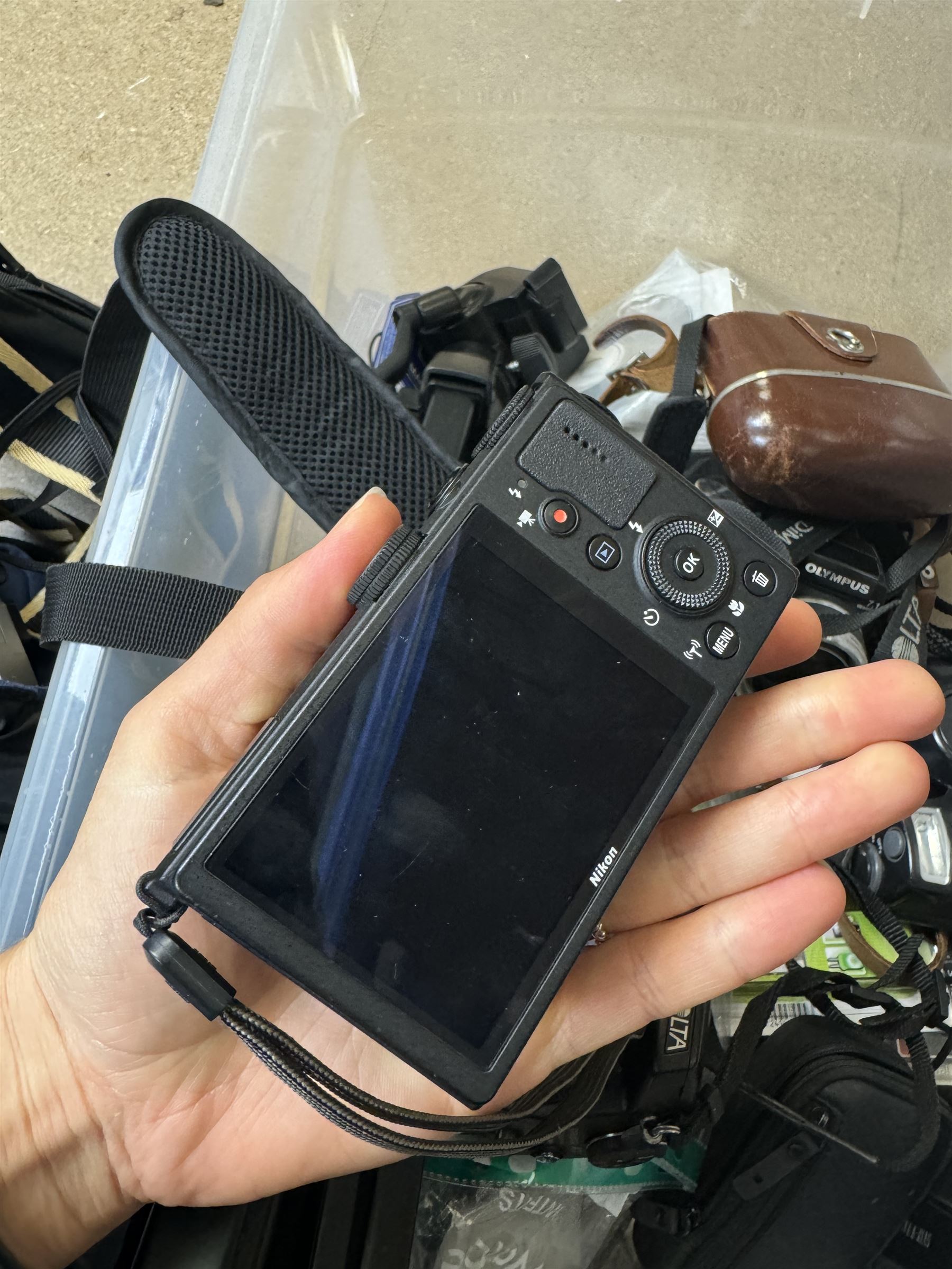 Collection of cameras and camera equipment, including Voigtlander Vitomatic I, Nikon Coolpix P340, Nikon Coolpix S9100, Olympus SP-510UZ, tripod, cases, etc