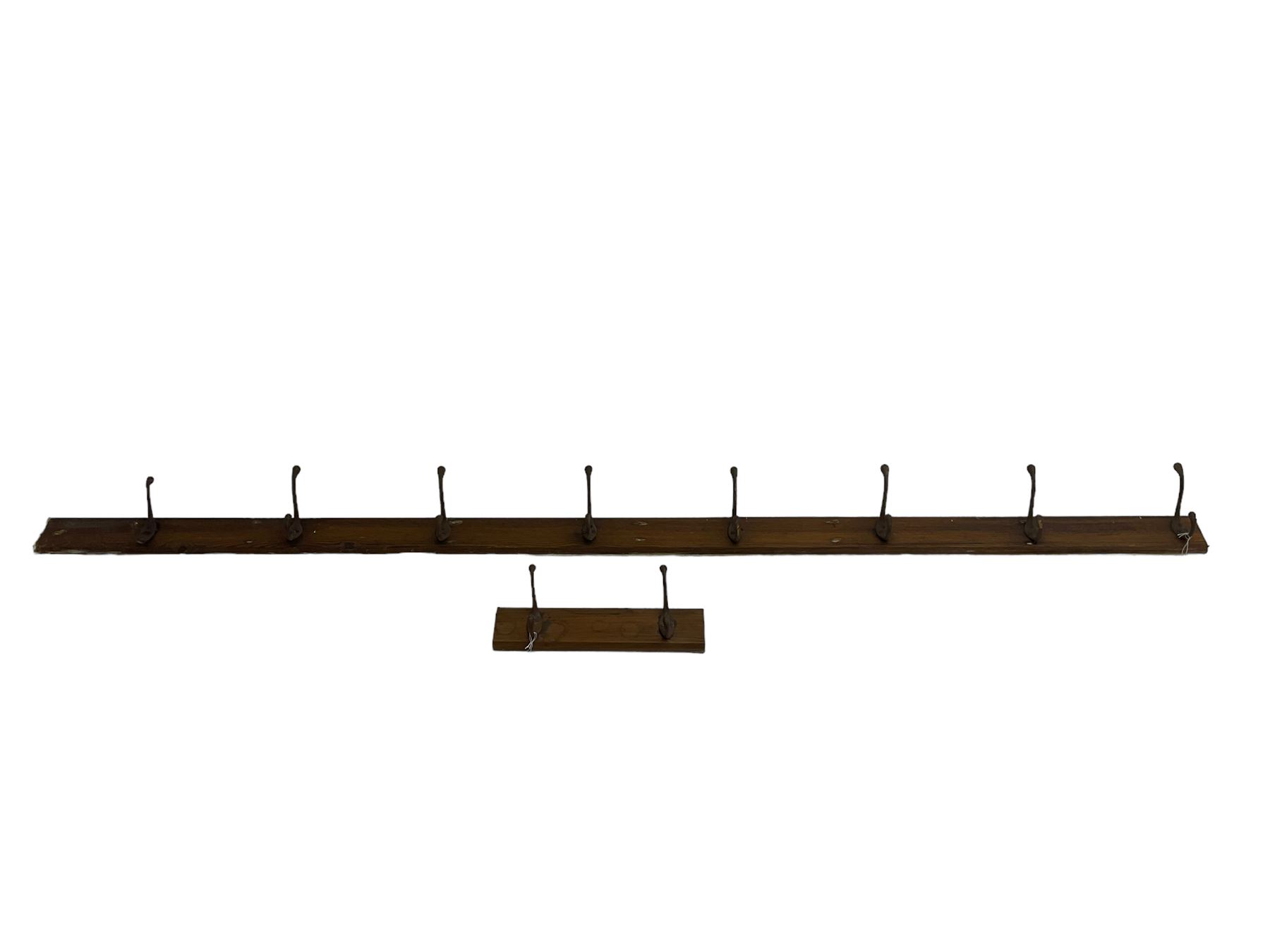 Late 19th century pitch pine wall hanging coat rail, fitted with metal hooks, two sections (longer section - L240cm; smaller section - 40cm)