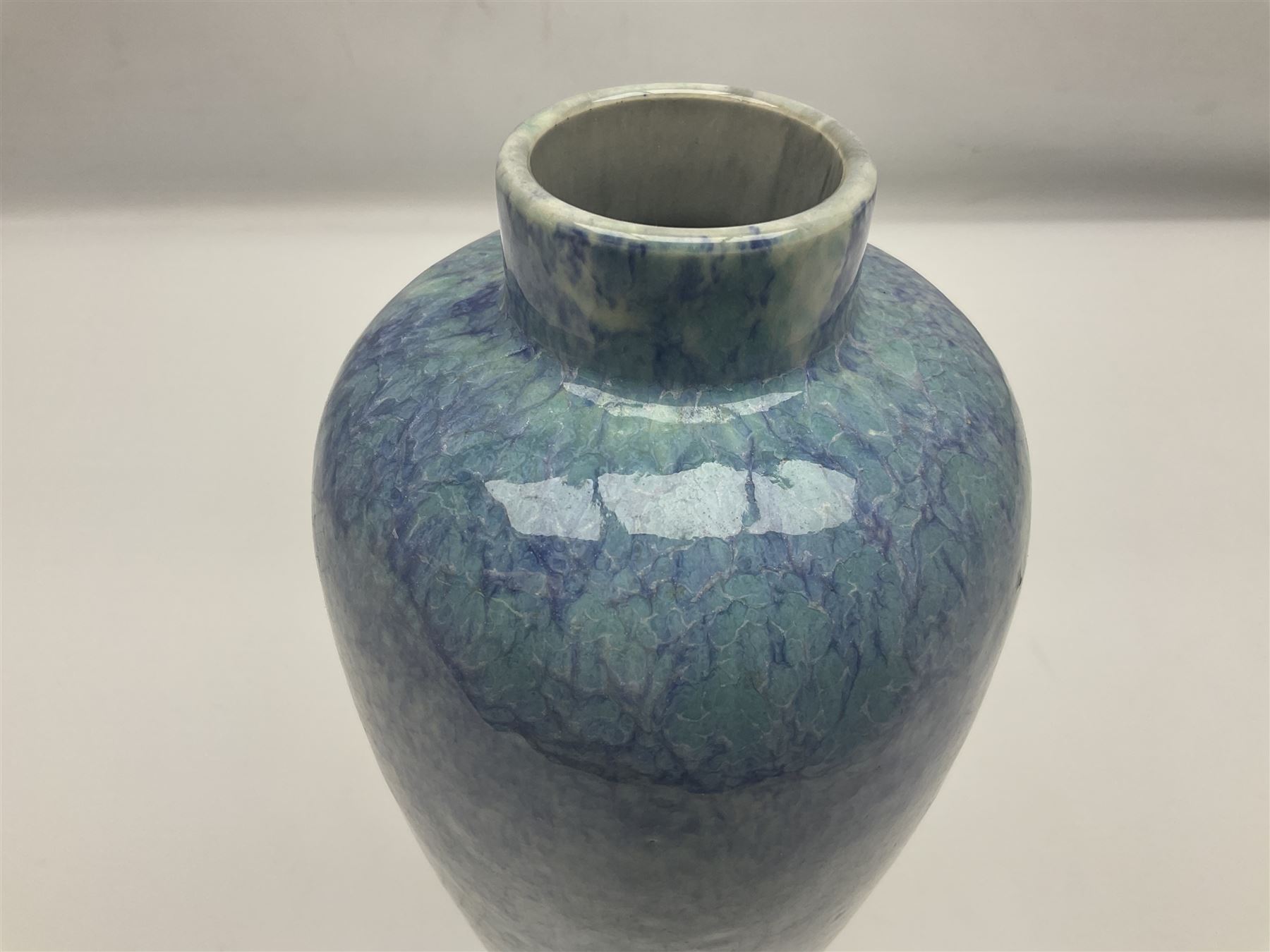 Holyrood Pottery vase of bulbous form decorated in a mottled and streaked green and blue glaze, with printed mark beneath, H24cm