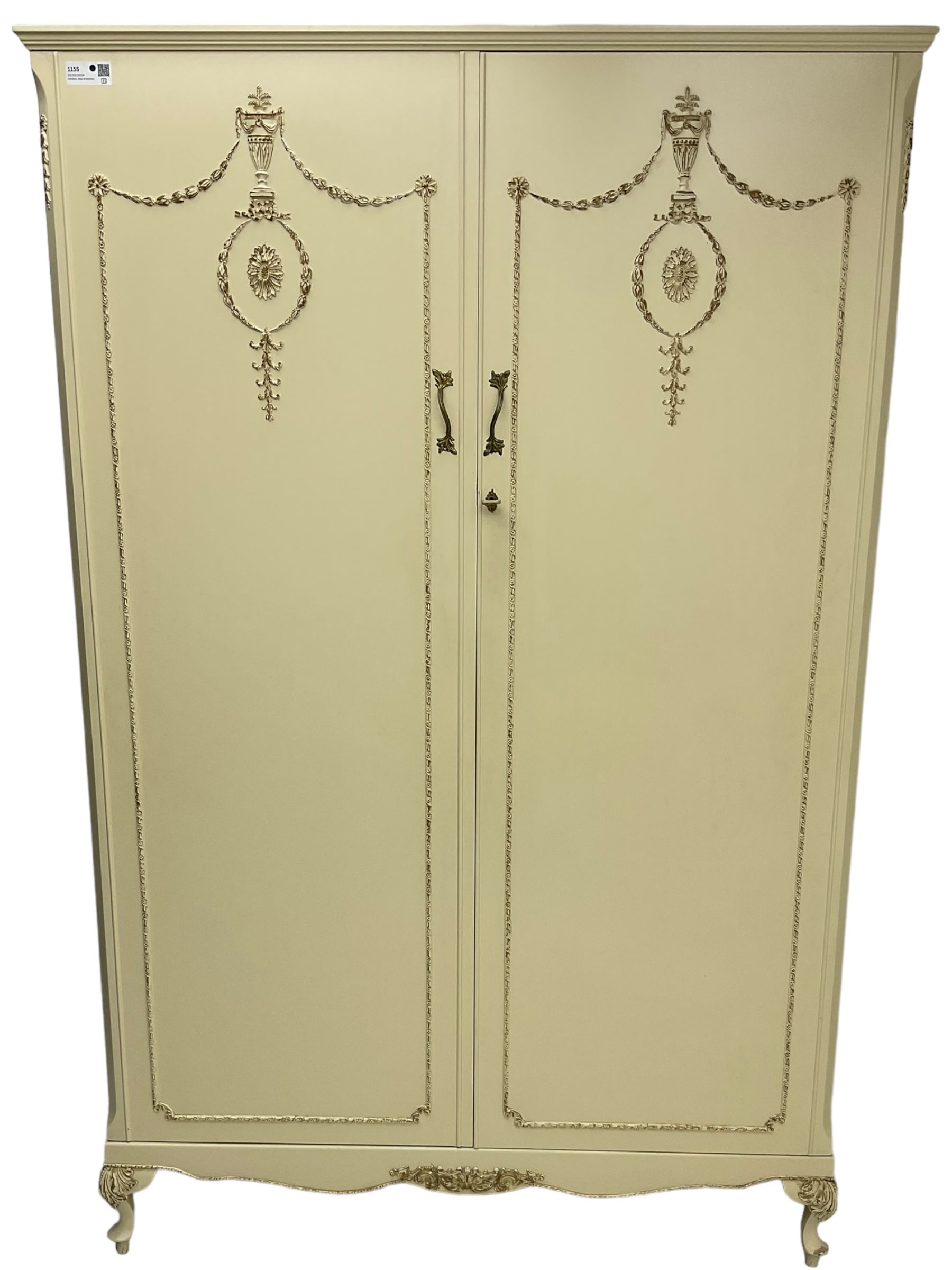 French classic design cream painted double wardrobe, the doors decorated with gilt and cream applied urn motifs with extending bell-flower festoons and ribbon twists, enclosing shelf and hanging rail, shaped apron on acanthus cabriole feet